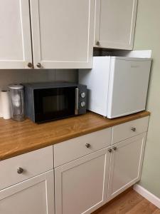 a kitchen counter with a microwave and a refrigerator at Lovely Comfortable Available in Hereford in Hereford +19 photos