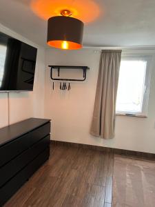 a room with a tv and a dresser and a window at Ferienhaus Luunsche Landpause in Lunow