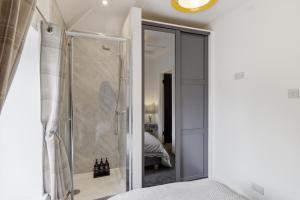 a bathroom with a shower and a glass door at Cannons Loft Central Buxton, Duplex loft 3 bedroom Set over 3 floors stairs no lift sleeps 5 in Buxton +35 photos