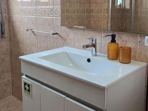 a bathroom with a white sink and a mirror at JB House in Peniche +23 photos
