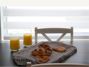 a table with two glasses of orange juice and bread at Buckie Central 2 bed Retreat 24 high street in Buckie
