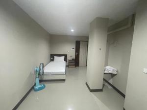 a white room with a bed and a desk at ภูมิพิมานเฮ้าส์ in Udon Thani