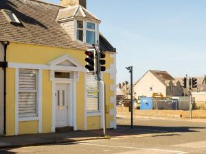 a traffic light in front of a yellow building at Buckie Central 2 bed Retreat 24 high street in Buckie +8 photos