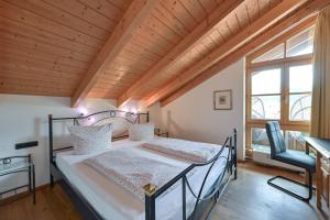 zwei Betten in einem Zimmer mit Holzdecke in der Unterkunft Ferienwohnung Edelweiß mit Sommer- Bergbahn unlimited kostenlos in Obermaiselstein