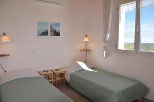 two beds in a room with two windows at Sea View Villa, 4-6 Guests in Cupra Marittima