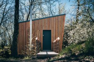 a small building with a blue door in the woods at Rokle Tiny house Plandry in Plandry +18 photos