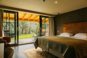 a bedroom with a large bed and a large window at Van der Valk Hotel Apeldoorn - de Cantharel in Apeldoorn +98 photos