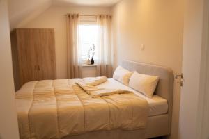 a bed sitting in a room with a window at Ferienwohnung Lindelskopf in Ludwigswinkel