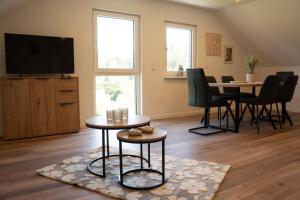 a living room with a table and a tv at Ferienwohnung Lindelskopf in Ludwigswinkel