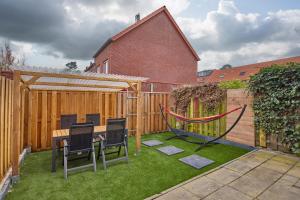 a backyard with a table and chairs and a hammock at Nimma Stays Nijmegen in Nijmegen