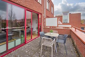 a patio with a table and chairs and a building at Nimma Stays Nijmegen in Nijmegen