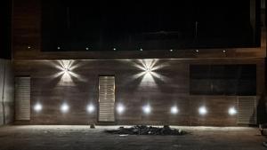 a building with lights on the side of it at night at Hotel Club Resort Místico in Coroaci