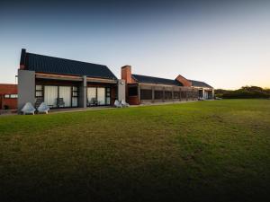 a building with a large grass field in front of it at Seebederfie in Great Brak River