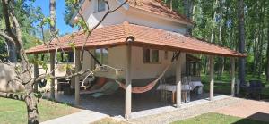 a gazebo with a hammock outside of it at Vikendica Sejšeli na Drini in Lipnički Šor