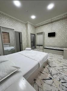 a large bedroom with a large bed and a television at Lola Hotel in Yangiyer