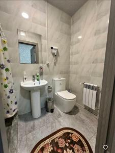 a bathroom with a toilet and a sink at Lola Hotel in Yangiyer