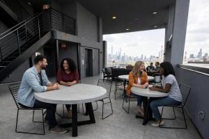 a group of people sitting at tables in a restaurant at Dutch Hotel Long Island City New York , Belvilla District 6 Formerly Sonder in Long Island City