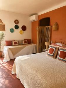 two beds in a bedroom with orange walls at Le Jardin d'Emile in Cassis