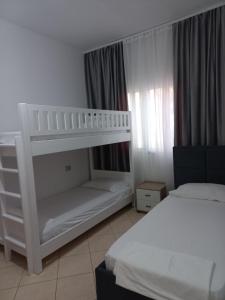 a bedroom with two beds and a bunk bed at Vila Familjare Memushi in Ksamil