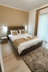 a bedroom with a large bed with a large window at Casa DIAMOND LUX&SPA in Sovata