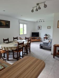 a living room with a table and chairs and a couch at La Maison de choupette in Fougerolles