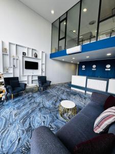 a living room with a couch and a tv at Hostly, New Boulevard Prime Stay in Batumi