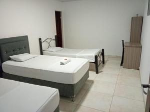a room with two beds in a room at Hotel Urdaneta AV in Neiva