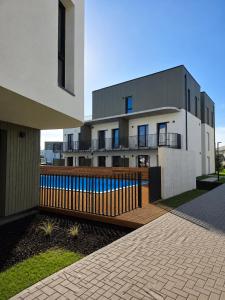 a building with a swimming pool in front of it at Pajūrio Namai in Palanga