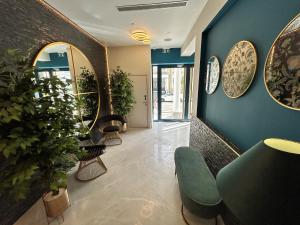 a waiting room with blue walls and plants at NOX Chelsea in London