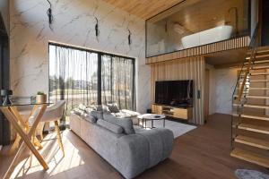 a living room with a gray couch and a staircase at Green Field Villa in Kuressaare +51 photos