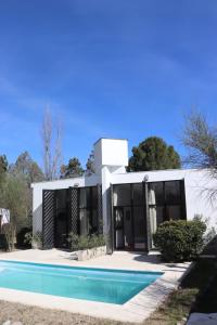 a house with a swimming pool in front of it at Las Artes Lodge in Mina Clavero
