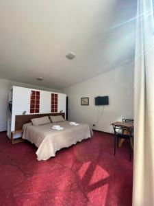 a bedroom with a large bed and a table at Las Artes Lodge in Mina Clavero +4 photos