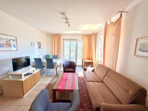 a living room with a couch and a tv at BELVEDERE - Lakeview Apartment 10 min from Lugano in Porza