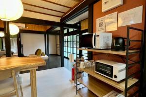 a living room with a microwave and a table at あざみ庵 奄美大島 in Amami