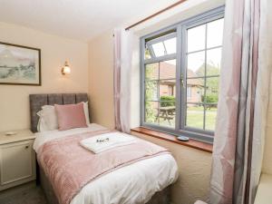a bedroom with a bed and a large window at Oak Tree in Weston-super-Mare