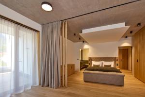 a bedroom with a bed and a large window at Das Lakeside - Move&Relax in Walchsee