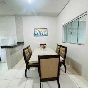 a dining room with a white table and chairs at casa mobiliada em gurupi in Gurupi