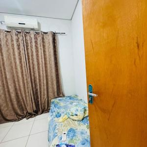 a door to a room with a bed and a window at casa mobiliada em gurupi in Gurupi
