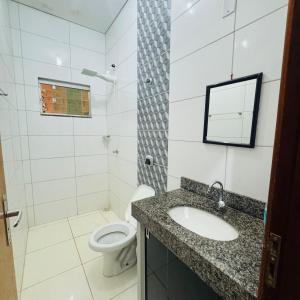 a bathroom with a sink and a toilet at casa mobiliada em gurupi in Gurupi