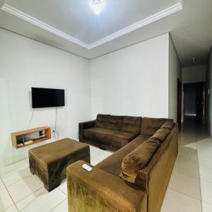 a living room with a couch and a flat screen tv at casa mobiliada em gurupi in Gurupi