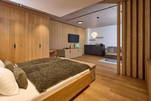 a bedroom with a large bed and a television at Das Lakeside - Move&Relax in Walchsee