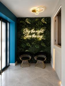 a lobby with two chairs and a green wall at NOX Chelsea in London