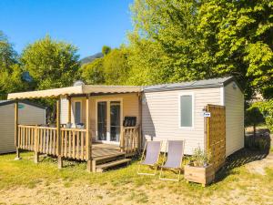 a tiny house with two chairs on a deck at Camping 3* Les Templiers in Roquebillière