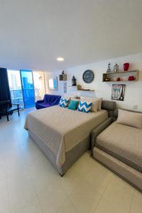 a bedroom with two beds and a couch at Loft playa y mar in Cartagena de Indias