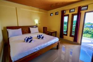 a bedroom with a bed with two pillows on it at Golo Tango Homestay in Labuan Bajo