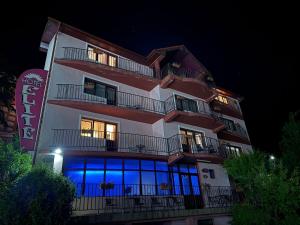 a tall building with blue lights on it at night at Hostel Elite in Băile Herculane