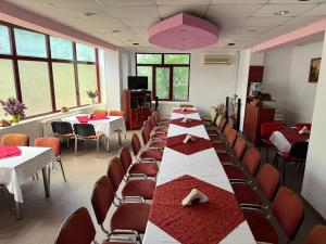 a row of tables and chairs in a room at Hostel Elite in Băile Herculane