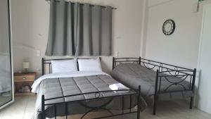 a bedroom with a bed and a window with a clock at Κτήμα Καρνέση 2 in Loutra Edipsou +18 photos