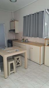 a kitchen with a table in the middle of it at Κτήμα Καρνέση 2 in Loutra Edipsou