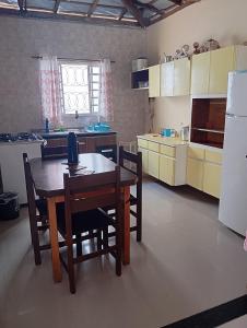 a kitchen with a table and chairs and a refrigerator at Sítio Araújo in Ibiúna